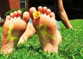 Feet without a fungus with a flower between your fingers